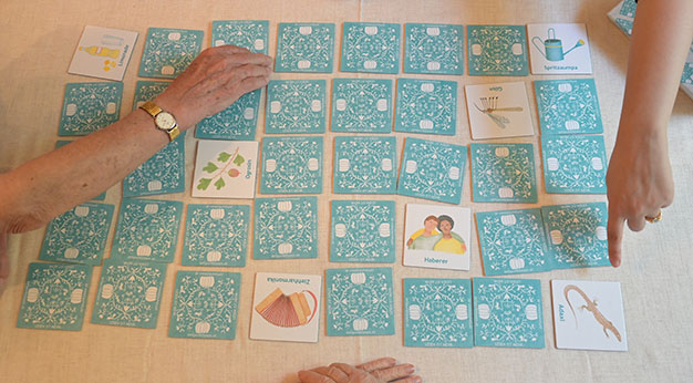 Drei Personen spielen mit dem Mundart-Memory